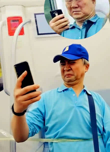 地铁老人看手机高清图片