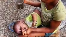 小孩子   非洲妈妈给小孩子拿手喂奶